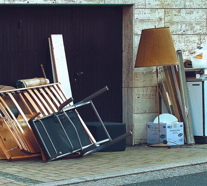 meubles usagés et encombrants entassés devant un bâtiment pour recyclage
