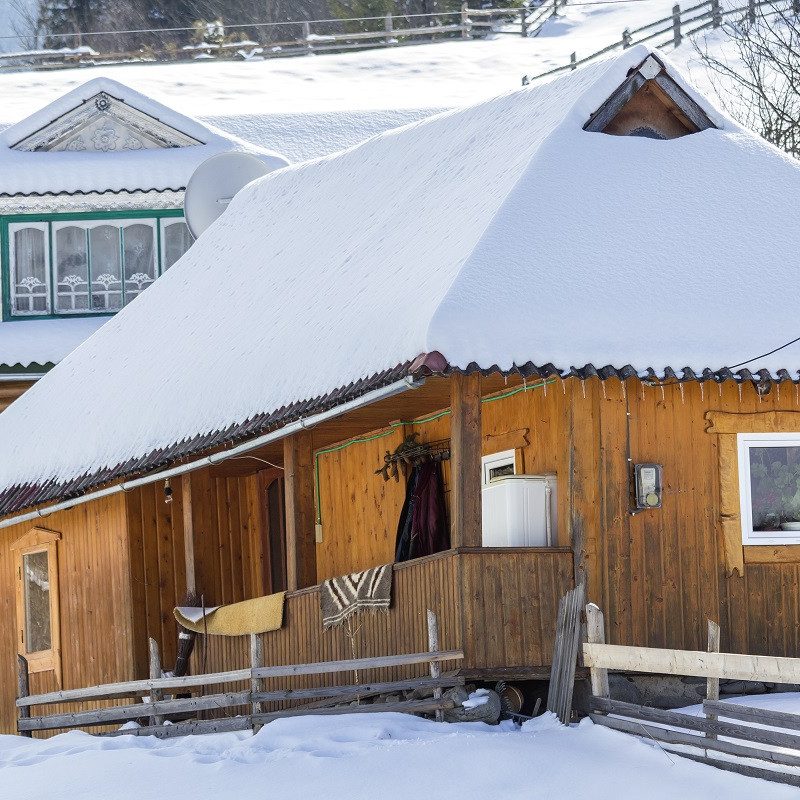 maison écologique en bois recouverte de neige avec toiture isolée, exemplaire d'architecture passive