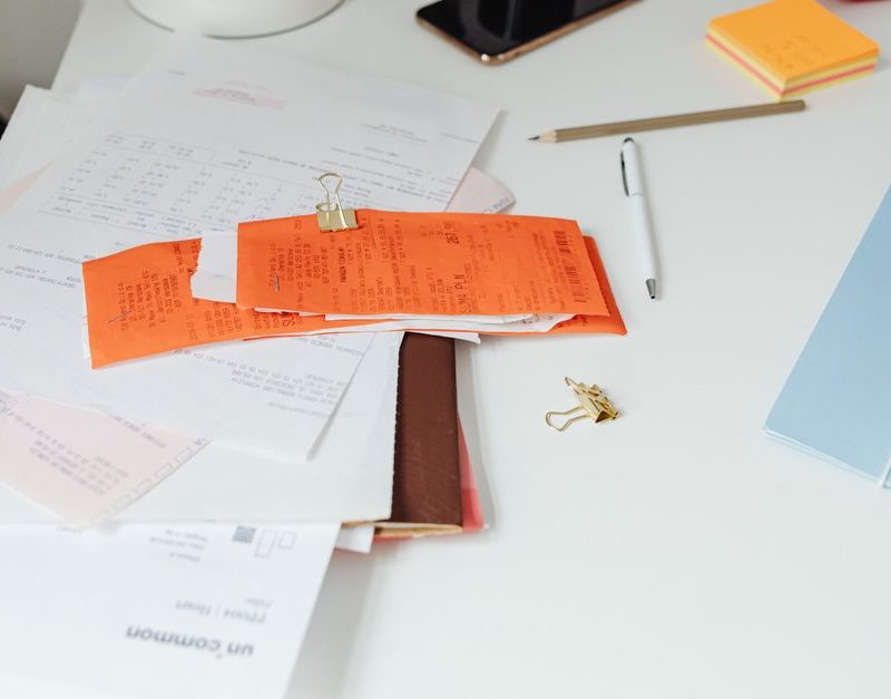 Close-up of a tidy desk with receipts, documents, and office stationery for business organization.