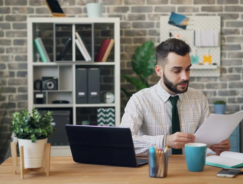 a man sitting at a desk in front of a laptop