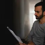 man in gray crew neck shirt holding white printer paper