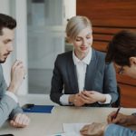 Business people signing a contract at a table.