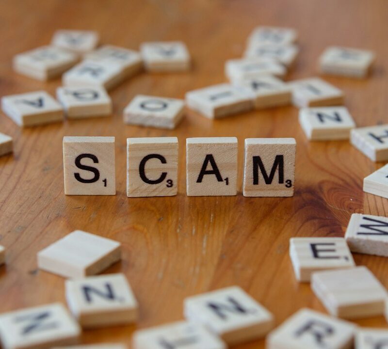 Scam spelled with scrabbles on a wooden table