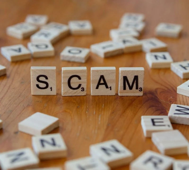 Scam spelled with scrabbles on a wooden table